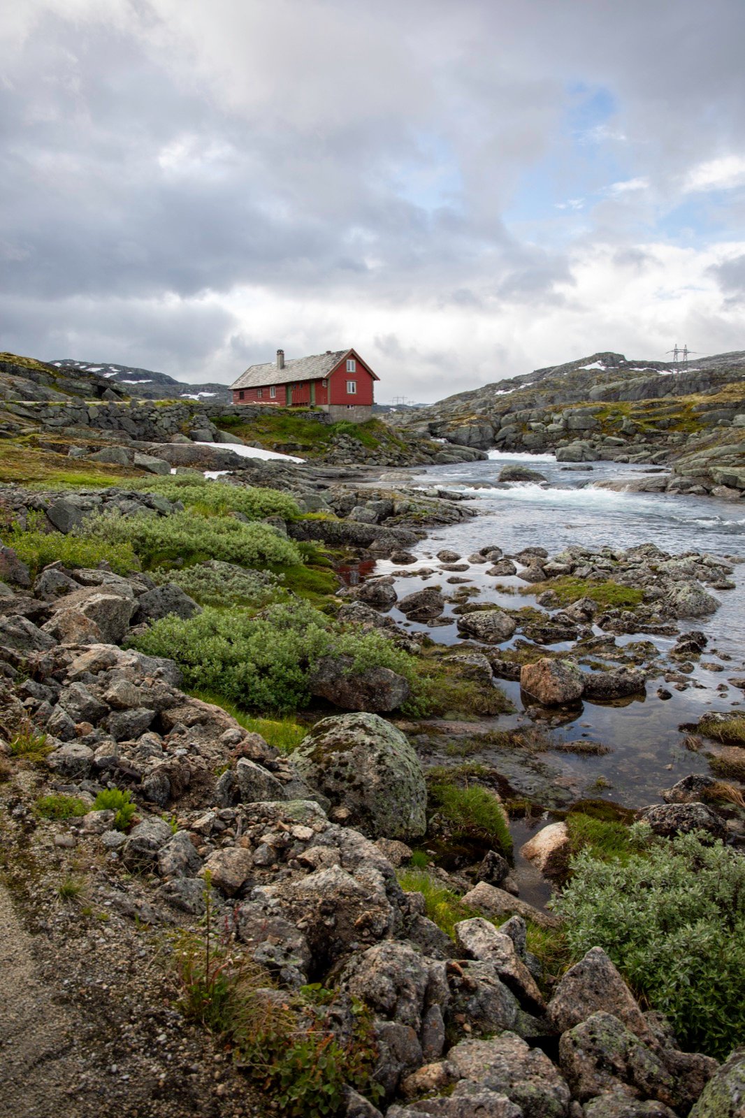 Red cabin beside a rocky river in the Norwegian highlands