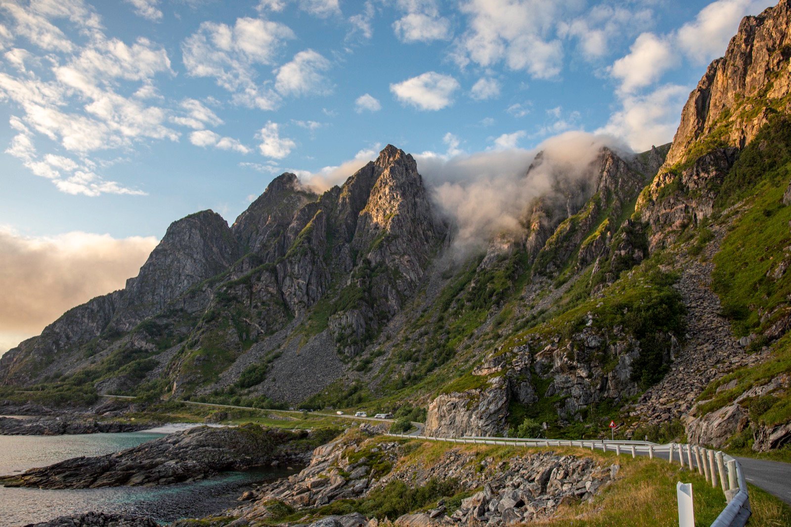 Winding coastal road beneath dramatic mountains in Norway