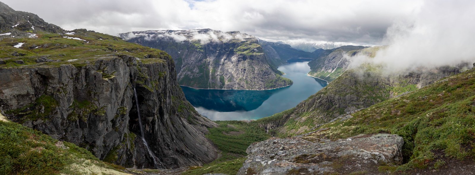 Panoramic view of a Norwegian fjord surrounded by cliffs and clouds