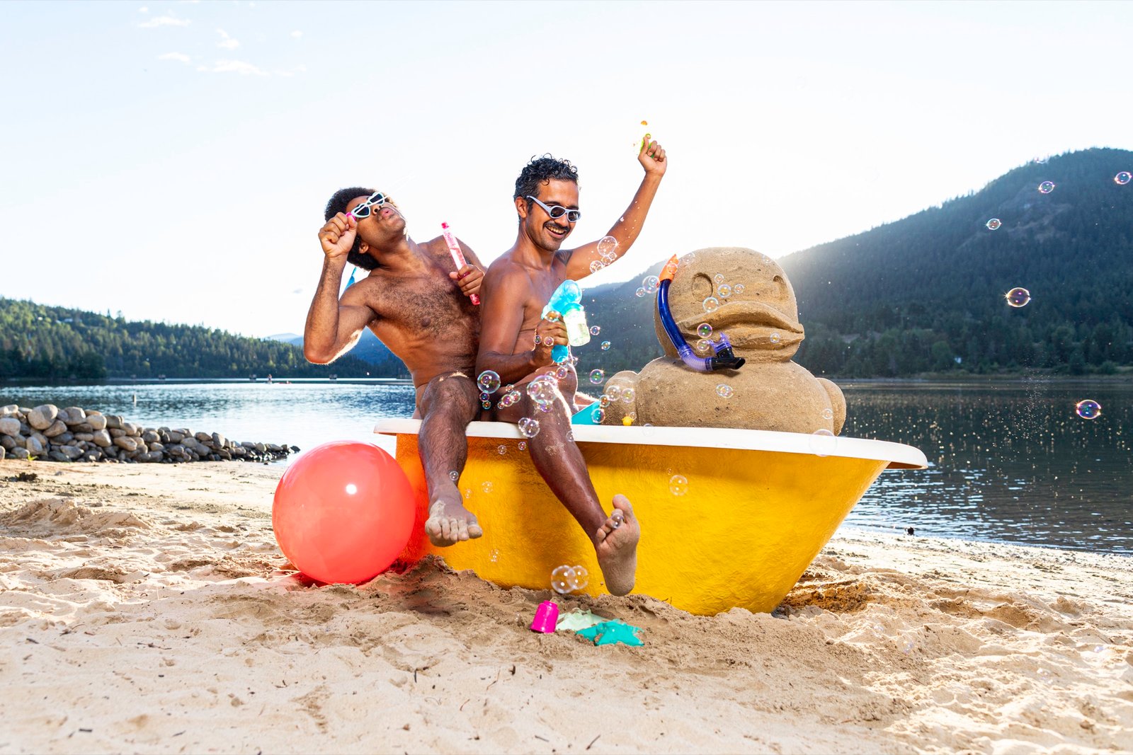 A clawfoot bathtub with a sand castle beside a mountain lake, Men in Tubs calendar